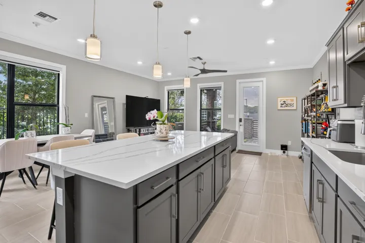 Kitchen featuring a large island with a light-toned countertop, gray cabinetry, recessed lighting, and tile flooring