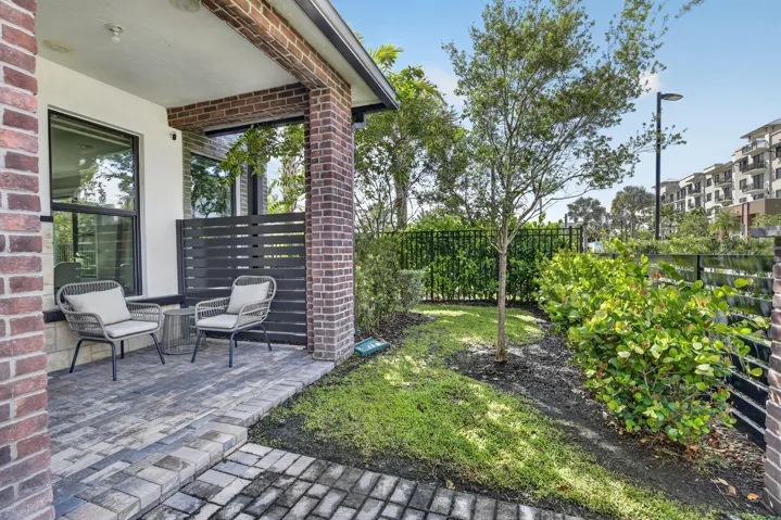 Brick exterior featuring a paver patio and a privacy screen