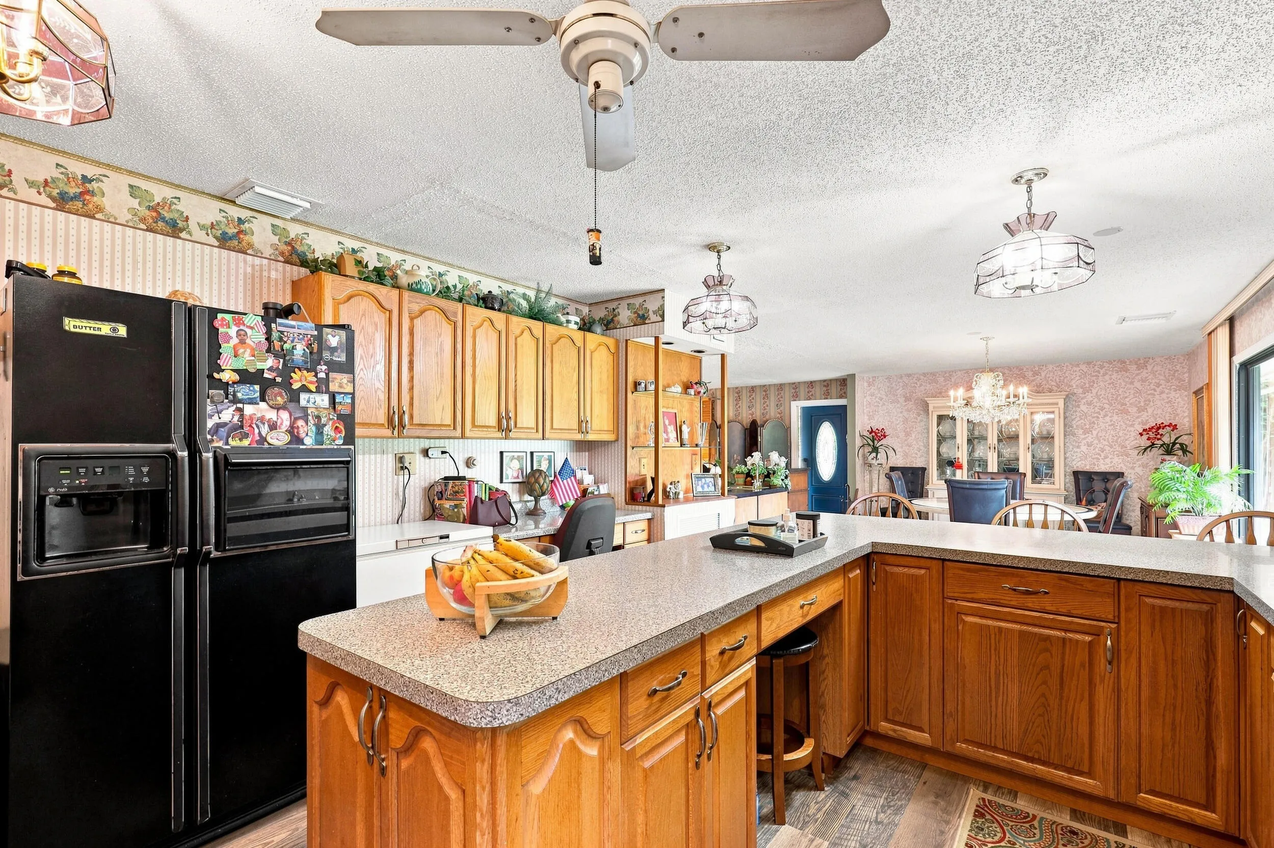 Additional kitchen view highlighting the center island, abundant cabinetry, and generous workspace.