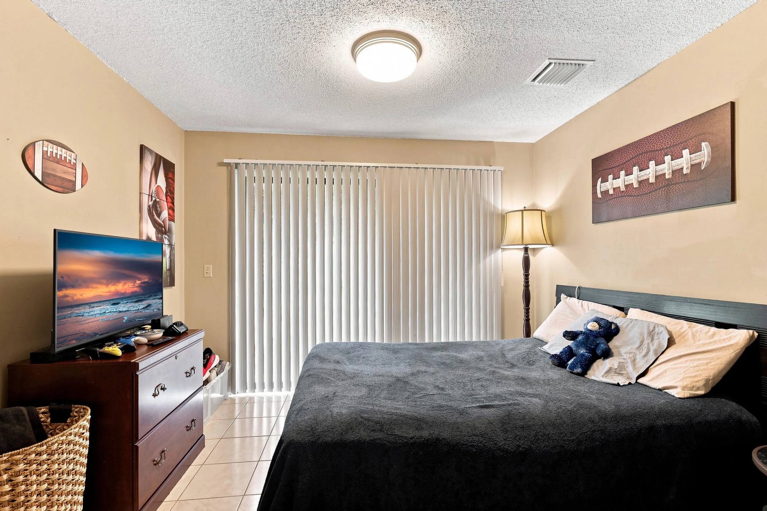 Comfortable secondary bedroom with ceiling fan, natural light, and sliding doors providing outdoor views.