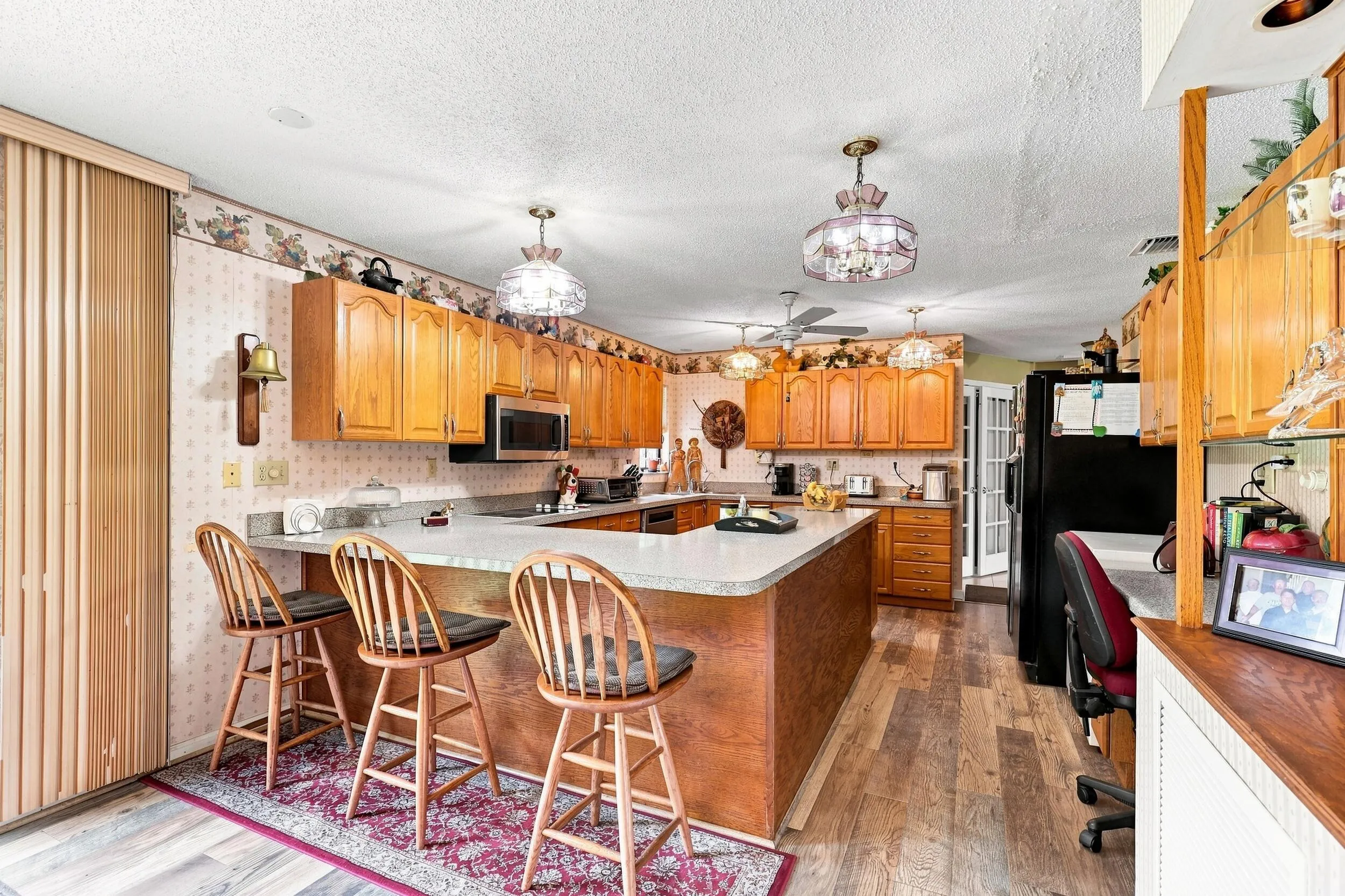 Spacious kitchen with abundant wood cabinetry, generous counter space, and breakfast bar seating.
