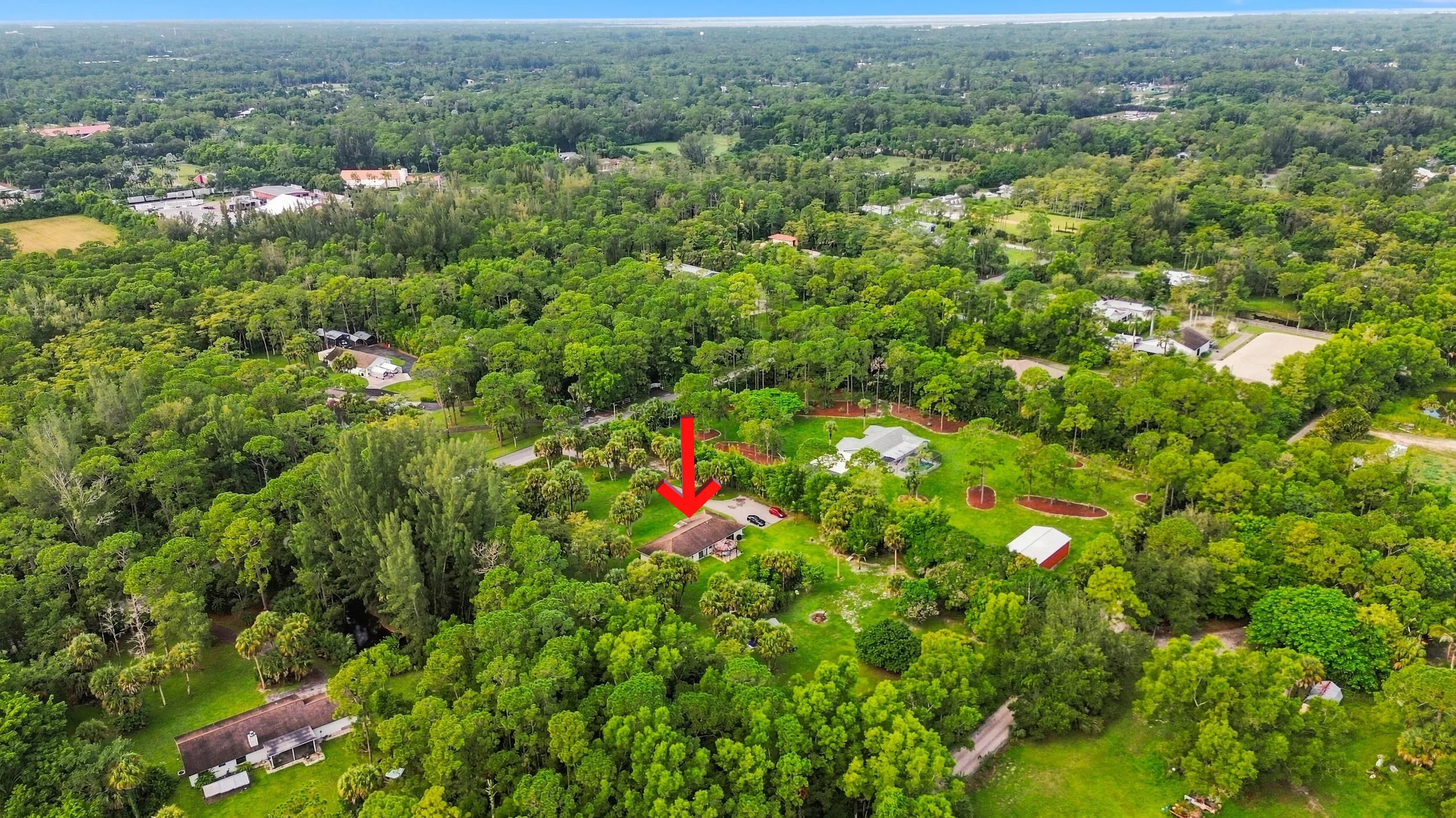 Wide aerial perspective showcasing the property’s private setting and surrounding large-acreage homesites.