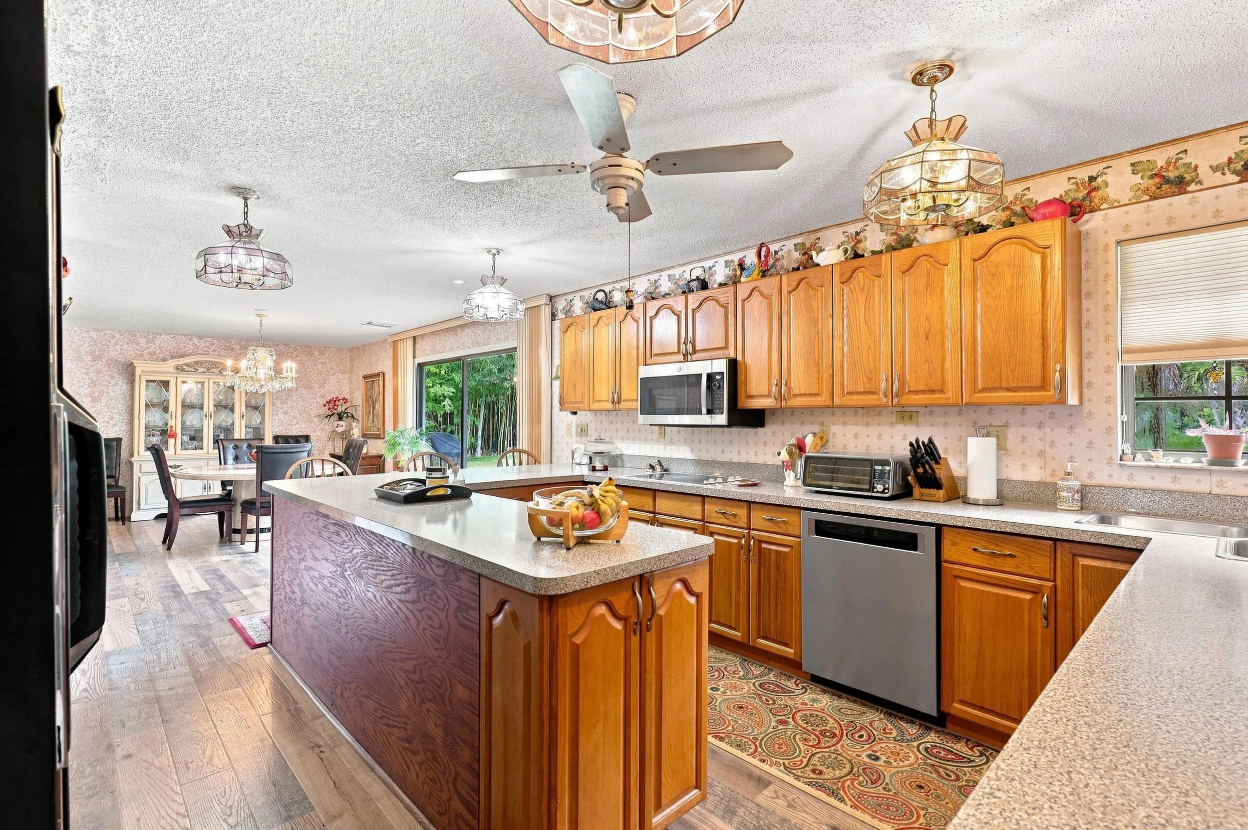 Spacious kitchen featuring abundant wood cabinetry, generous counter space, center island, and an open connection to the adjoining living areas.