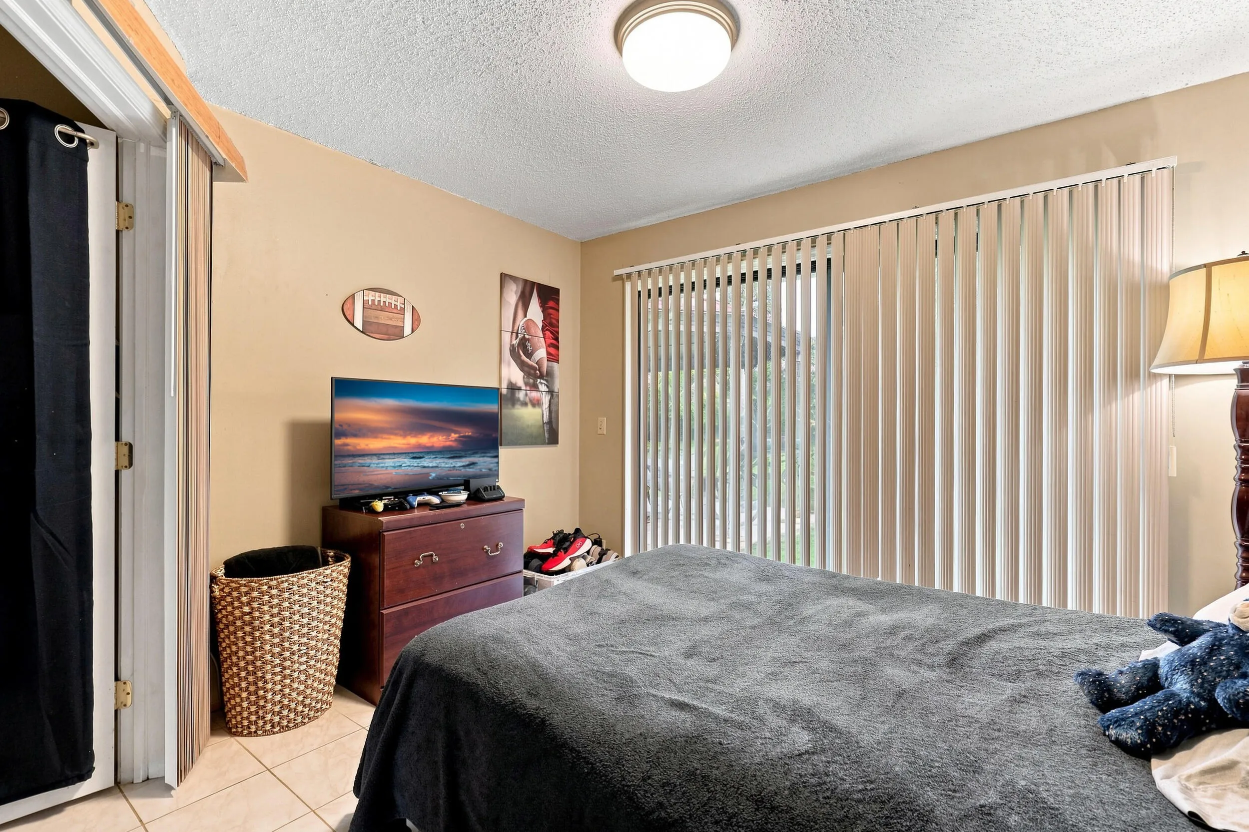 Comfortable secondary bedroom with natural light and sliding doors providing outdoor views.