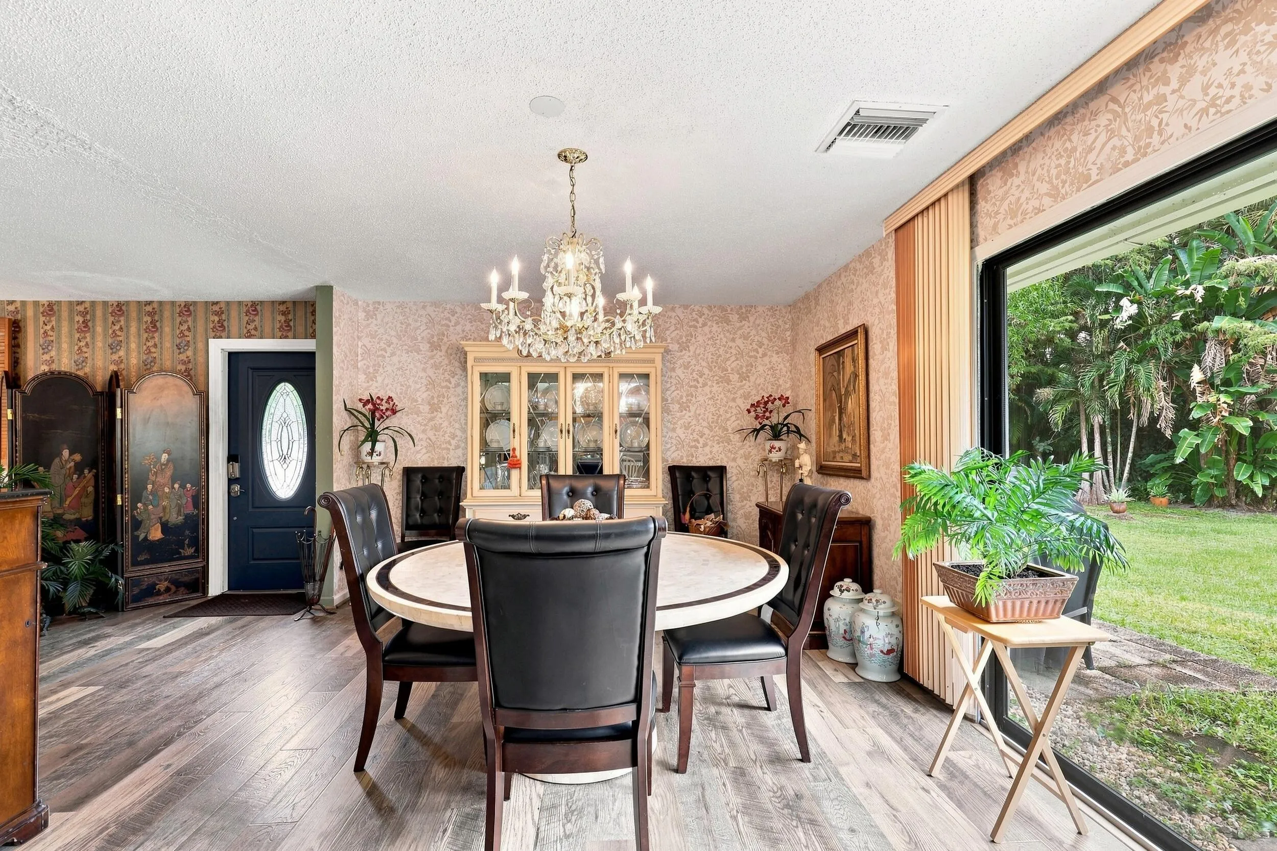 Bright dining area featuring large sliding doors overlooking the lush outdoor surroundings.