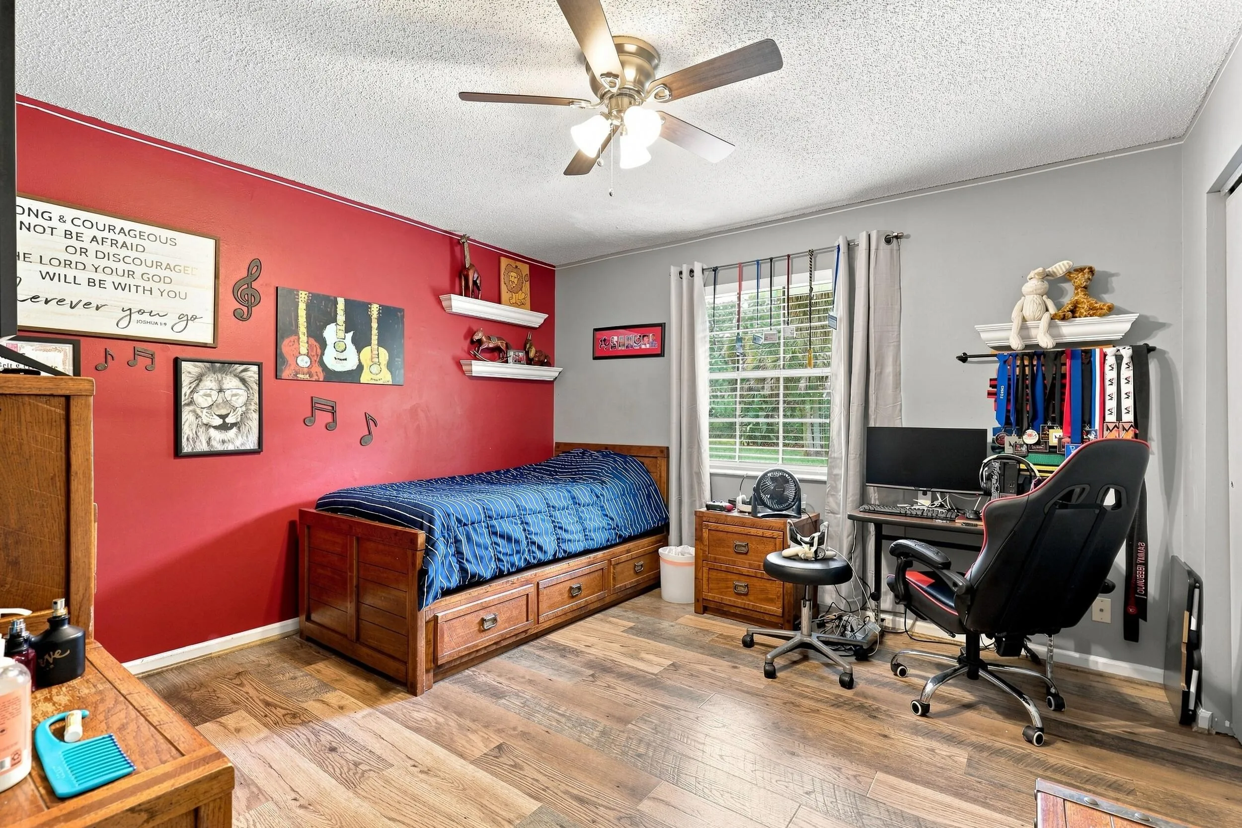 Comfortable bedroom with updated flooring, ceiling fan, and natural light.