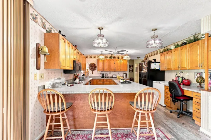 Spacious kitchen with abundant wood cabinetry, generous counter space, and breakfast bar seating.