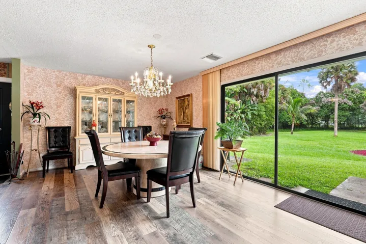 Bright dining space featuring a large sliding glass door overlooking the expansive backyard.