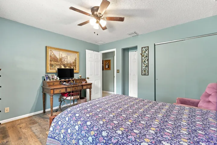 Spacious bedroom with ceiling fan, updated flooring, and room for additional furnishings.