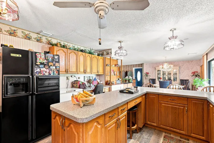 Additional kitchen view highlighting the center island, abundant cabinetry, and generous workspace.