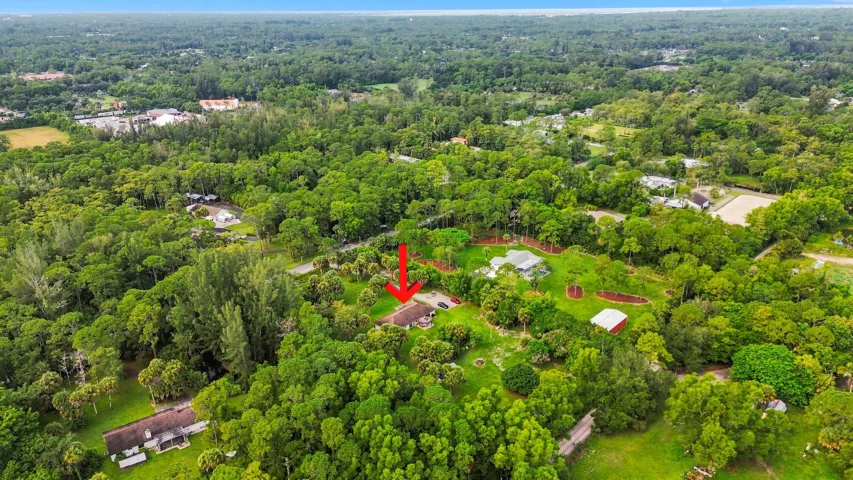 Wide aerial perspective showcasing the property’s private setting and surrounding large-acreage homesites.
