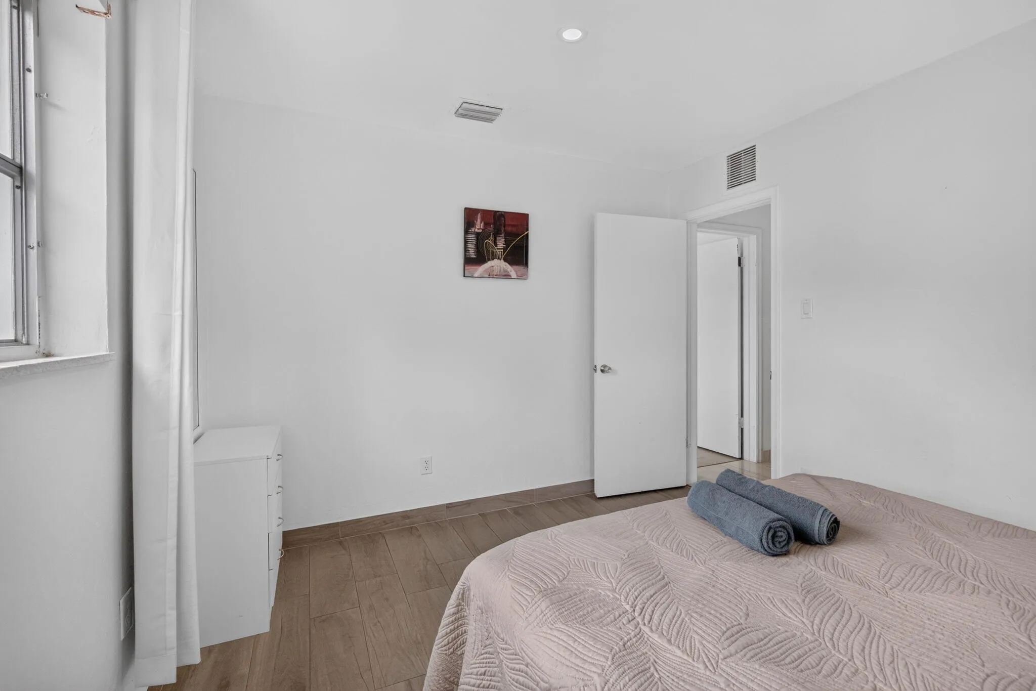 Third Bedroom with Wood-Look Flooring and Hallway Access