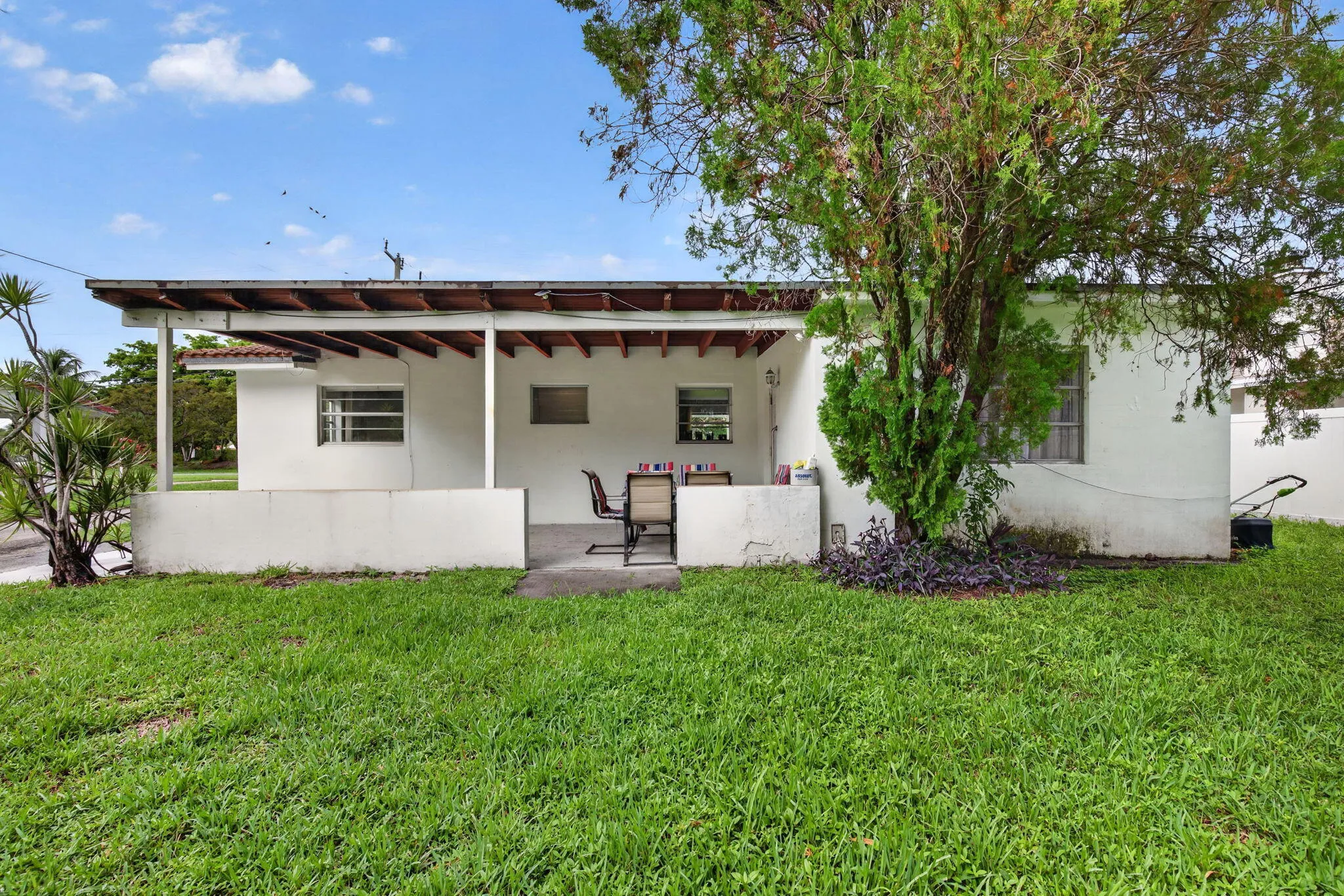 Rear Exterior — Covered Patio/carport and Wide-Open Lawn with Room for a Pool