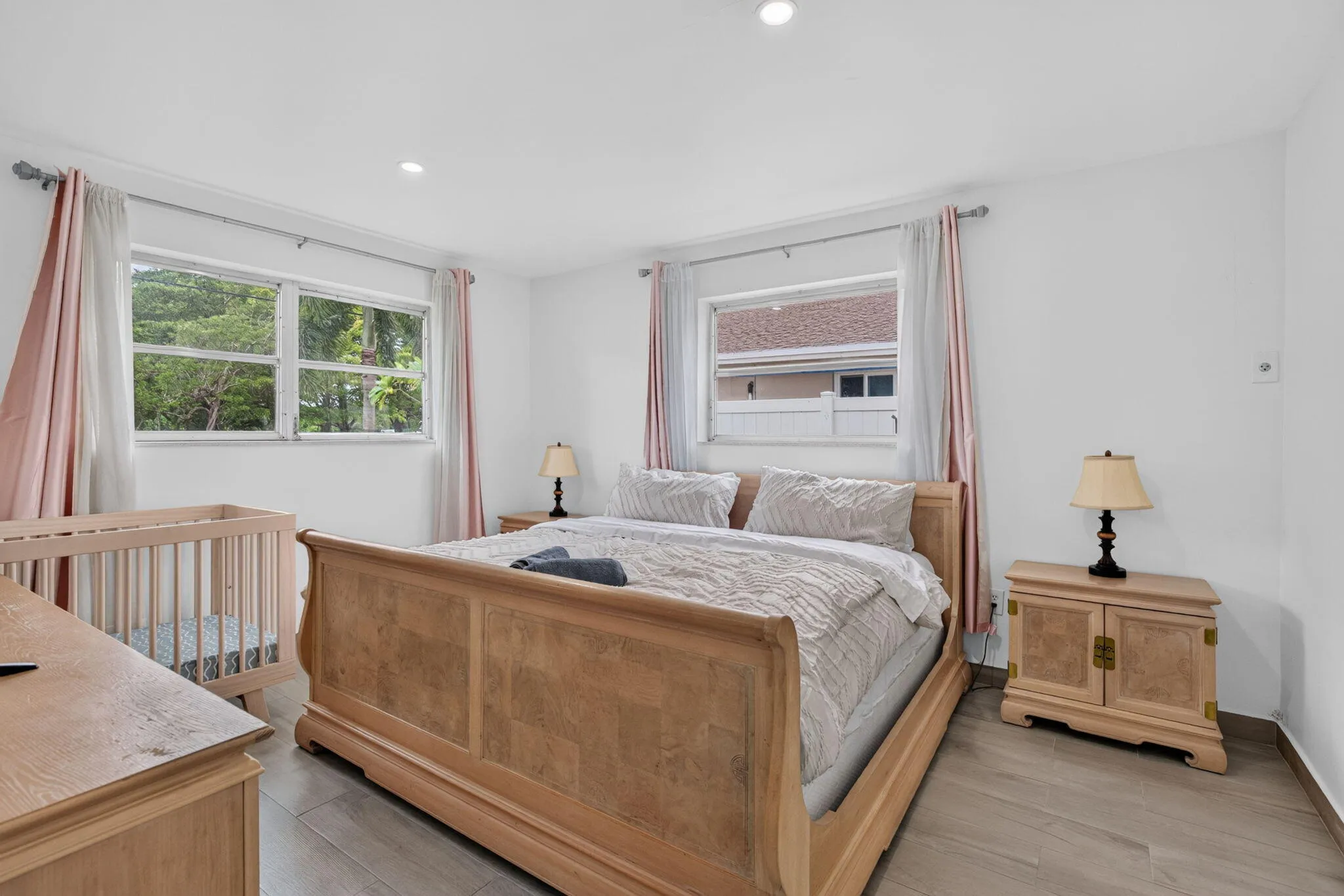 Primary Bedroom — King Suite with Dual Windows and Wood-Look Flooring