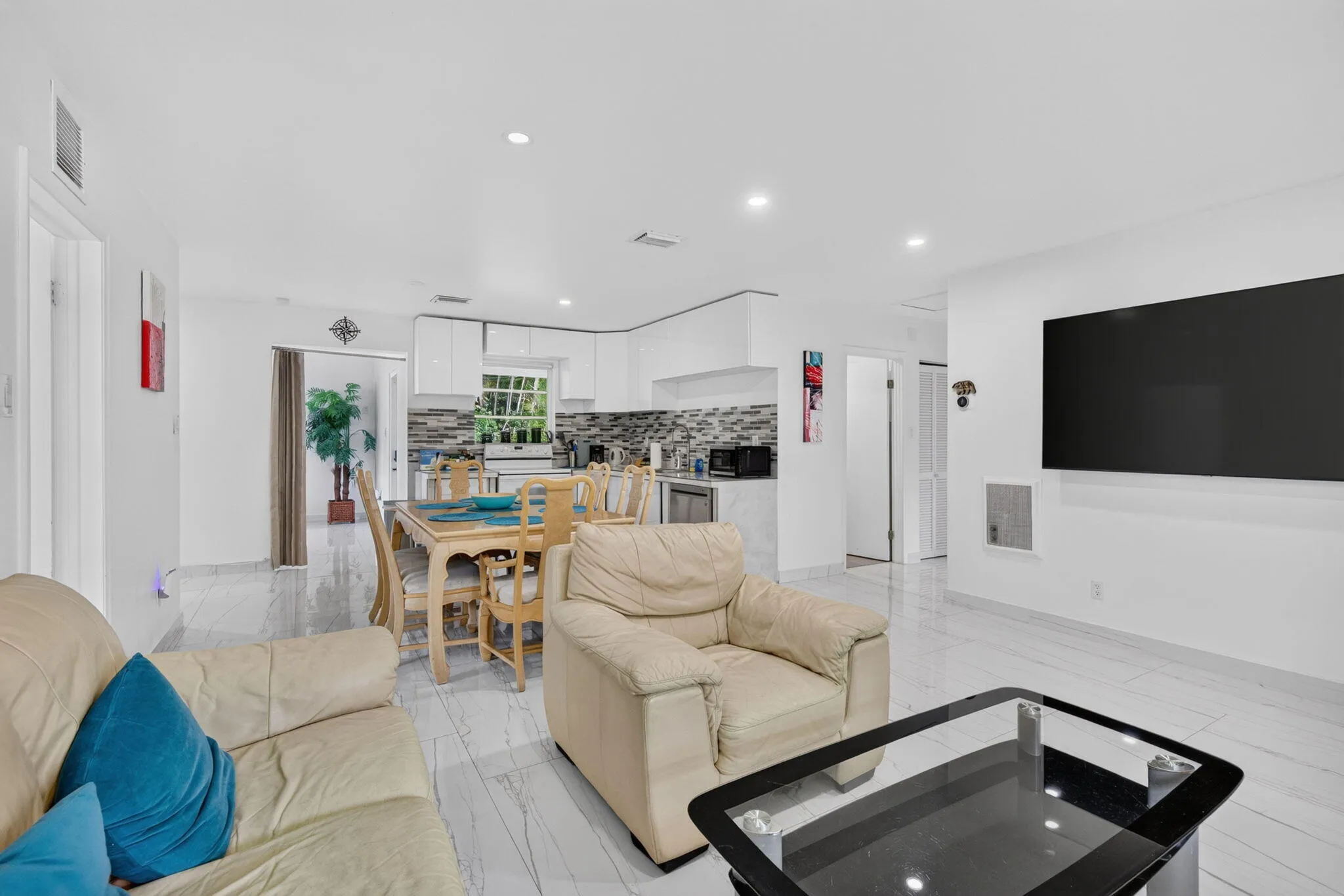 Spacious Living Room with Mounted Smart TV — Flowing Open Floor Plan