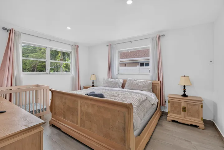 Primary Bedroom — King Suite with Dual Windows and Wood-Look Flooring