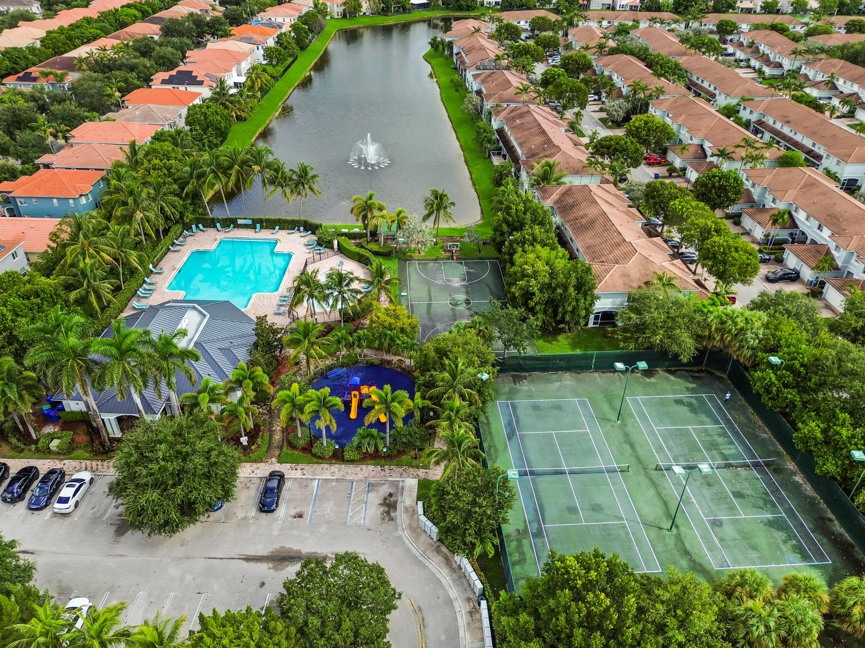 Community features include a large swimming pool, tennis courts, basketball court, and a pond with a fountain