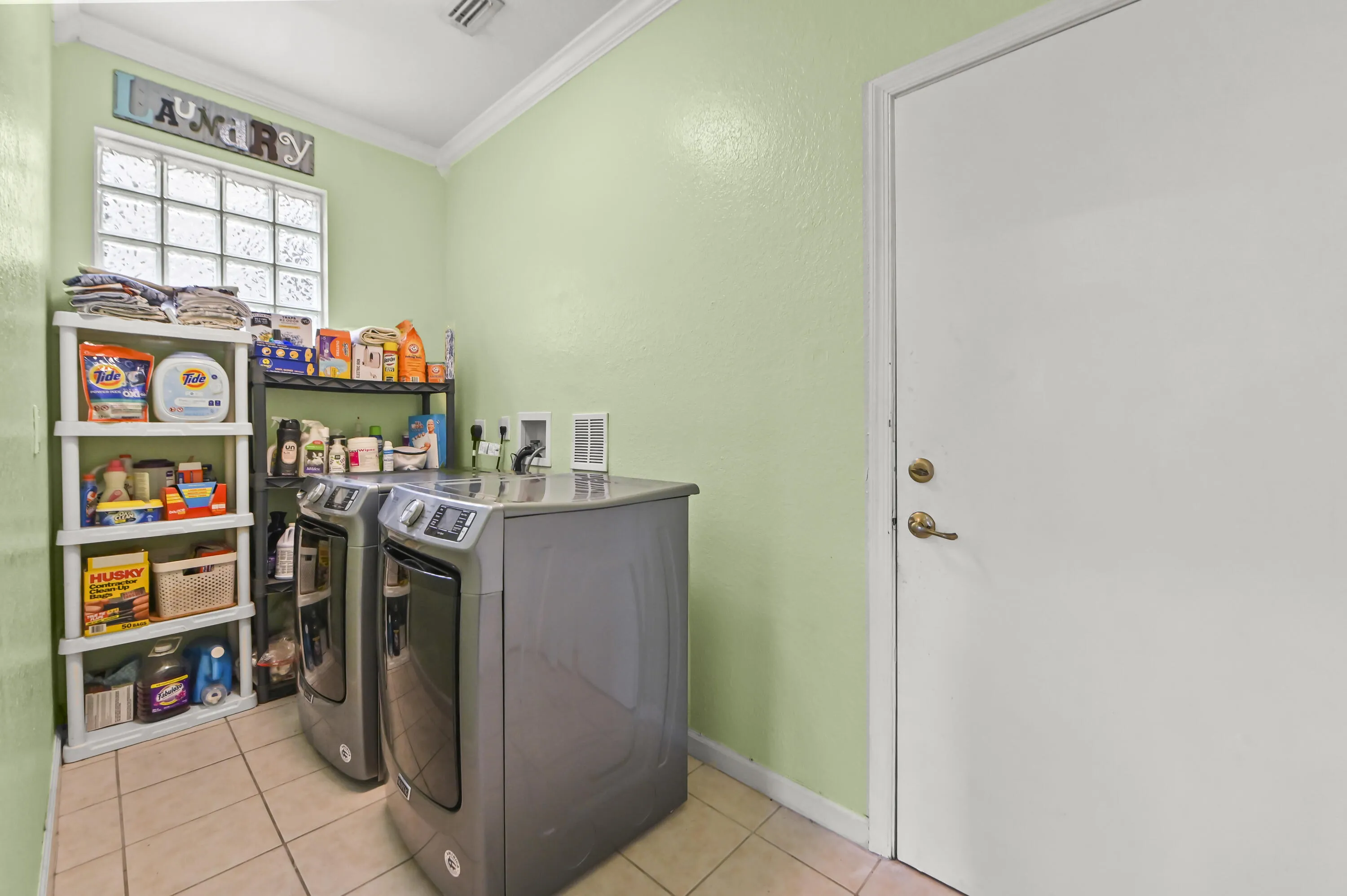 Ceramic tile flooring, crown molding, and a glass block window