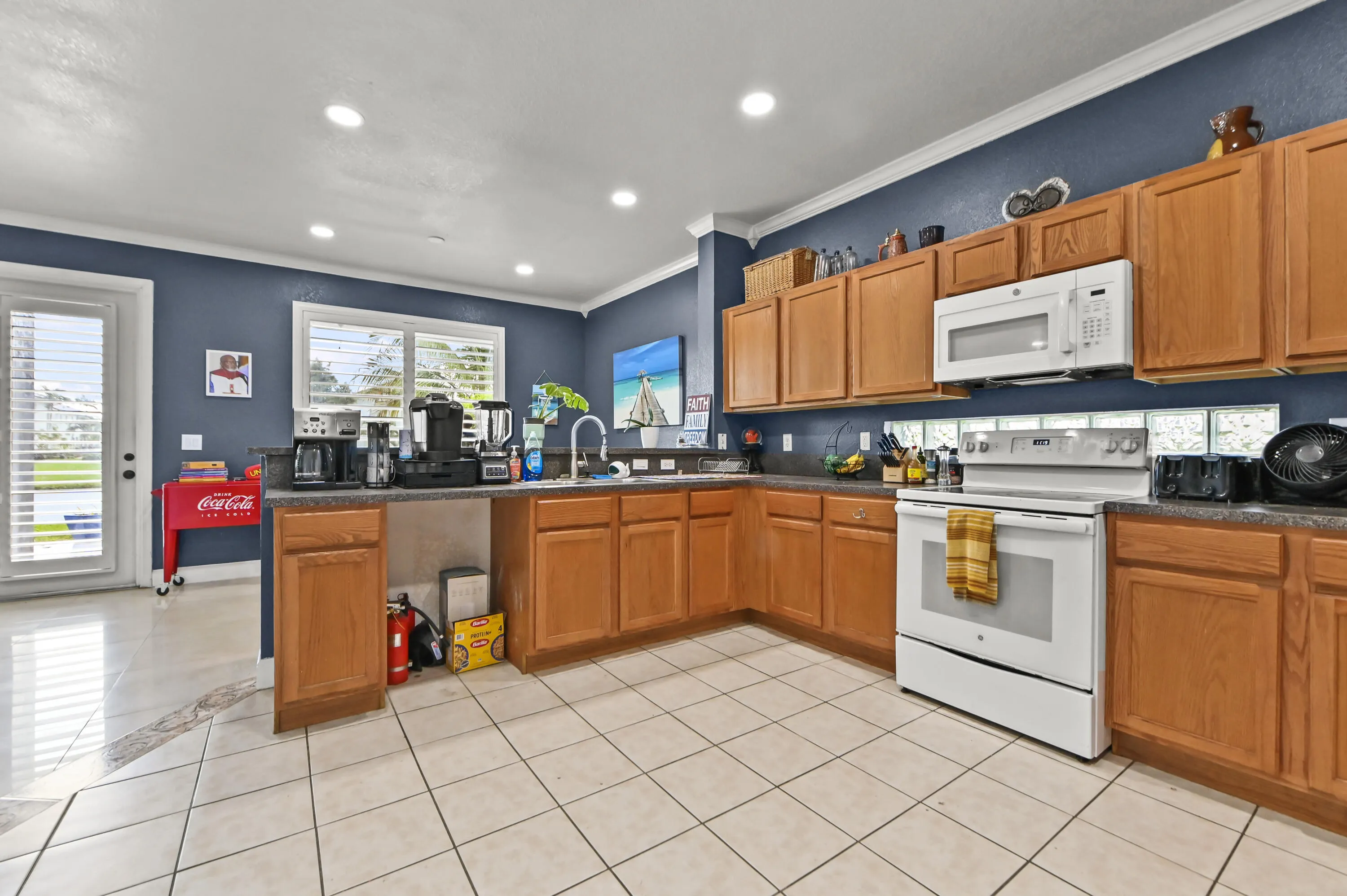 Kitchen with wood cabinetry, tile flooring, recessed lighting, and an overhead microwave