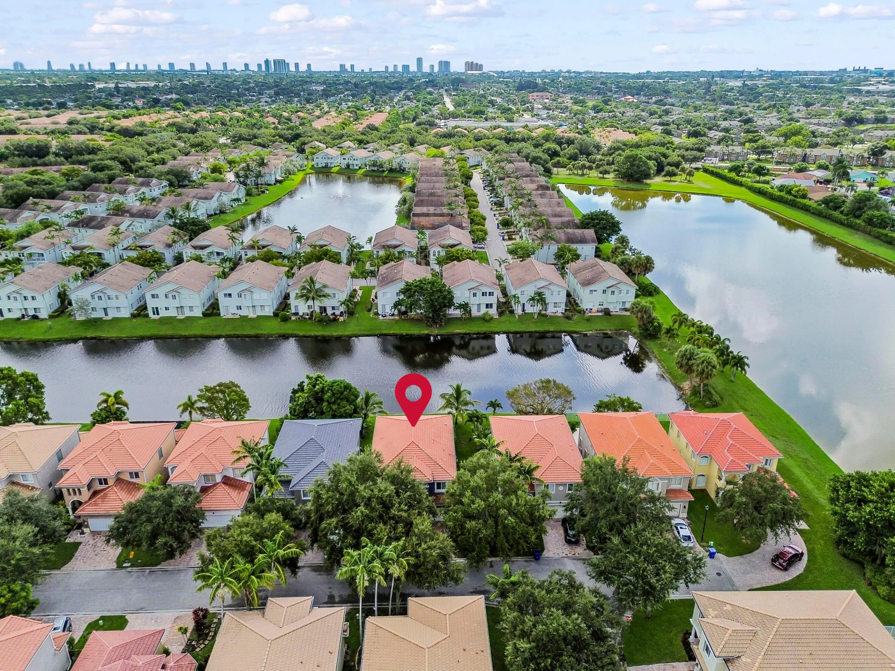 Aerial perspective highlighting residential properties, natural waterways, and a distant city skyline
