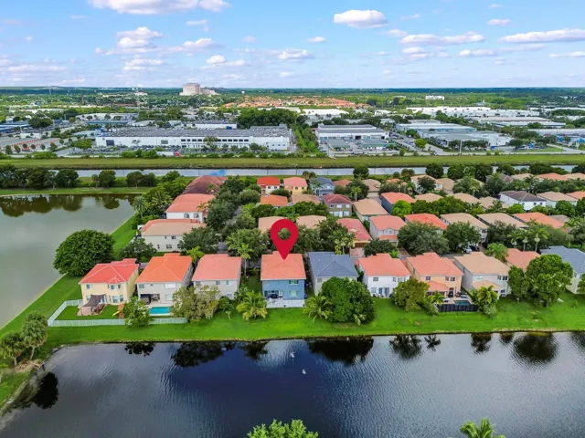 Waterfront residential community featuring distinctive red-tile roofing, mature landscaping with established trees, and direct water access