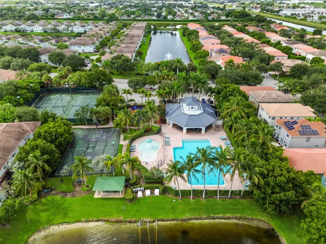 Community pool with adjacent cabana, tennis courts, basketball court, and tranquil water features