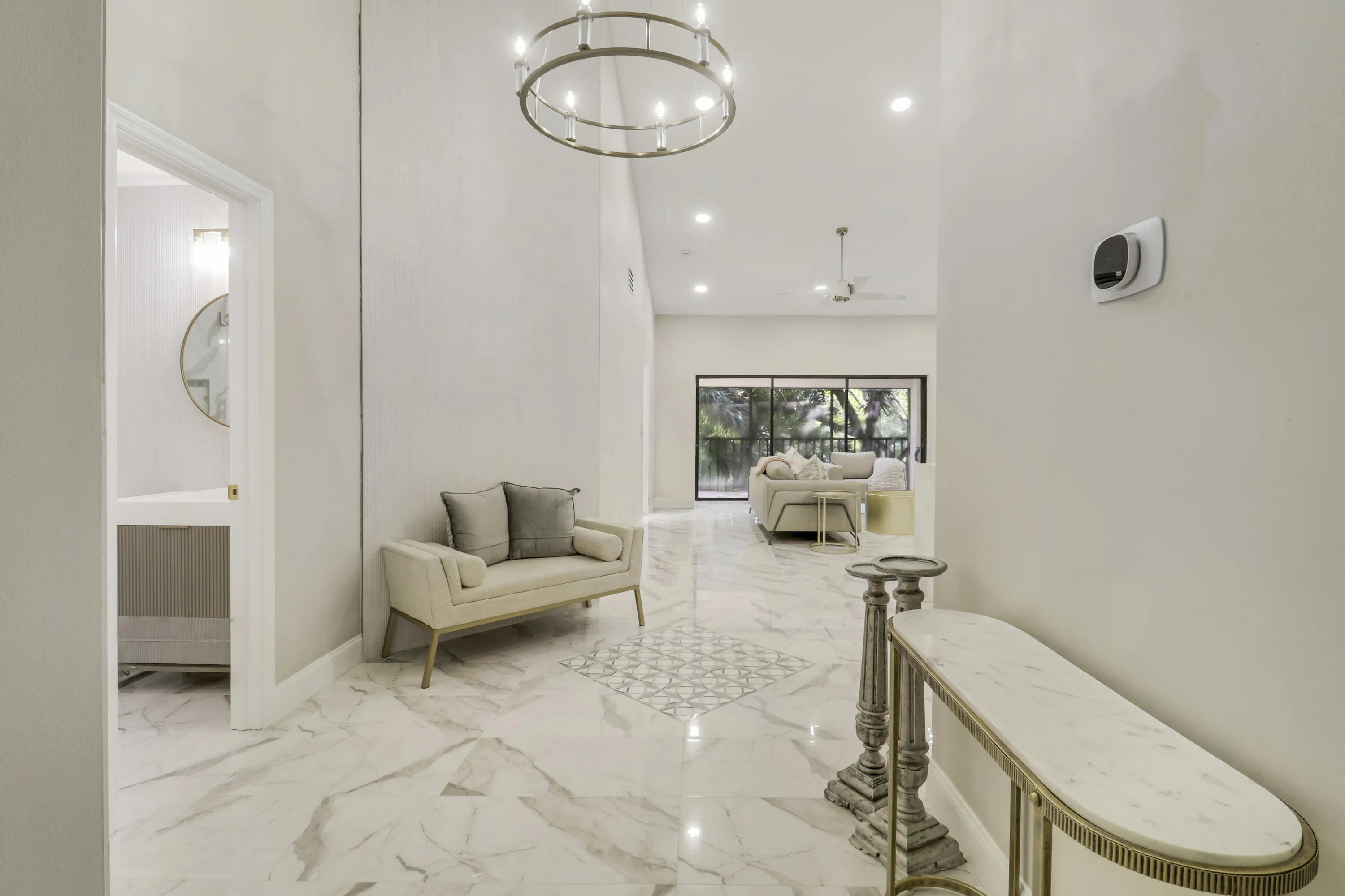 Vaulted ceiling with a chandelier, tile flooring, recessed lighting, and a partial bathroom with a wall-mounted vanity