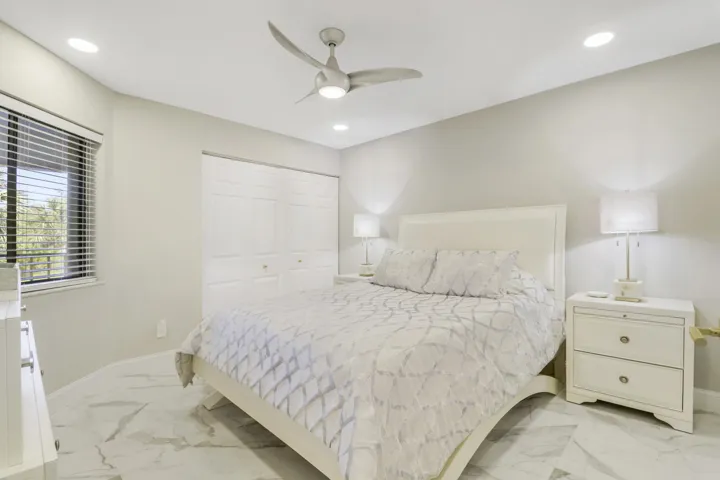 White paneled bi-fold closet doors, recessed lighting, and a contemporary ceiling fan