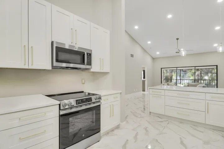 Modern kitchen featuring white shaker cabinetry, stainless steel appliances, and sleek countertops