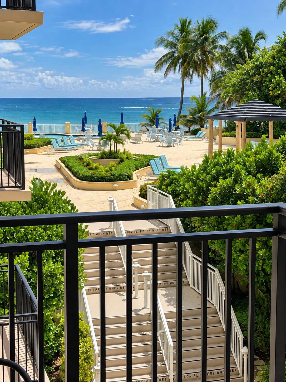 Expansive outdoor common area with ocean frontage, multiple seating areas, a shaded gazebo, and direct access stairs