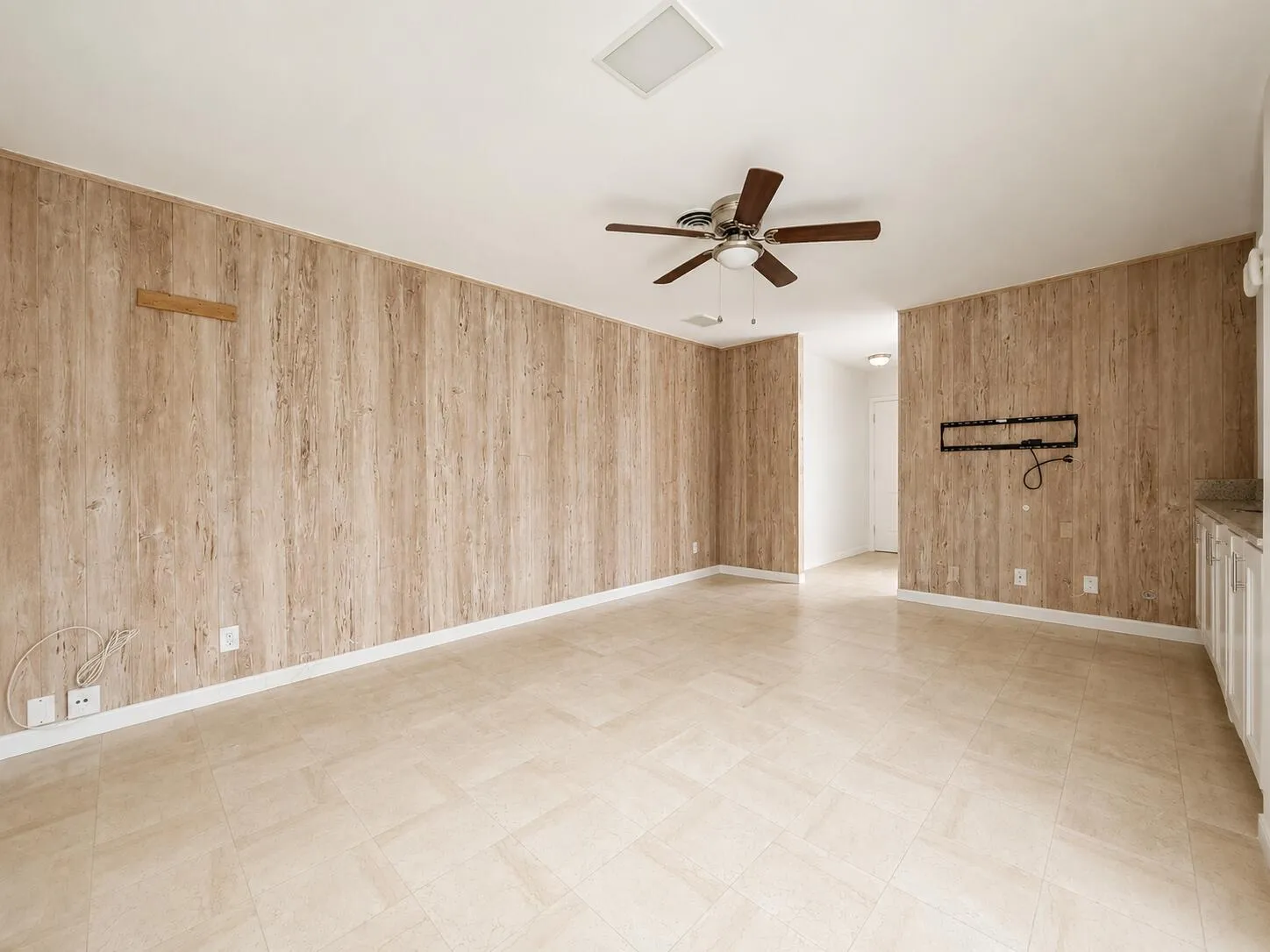 Wood-finish wall paneling, tiled flooring, and a ceiling fan