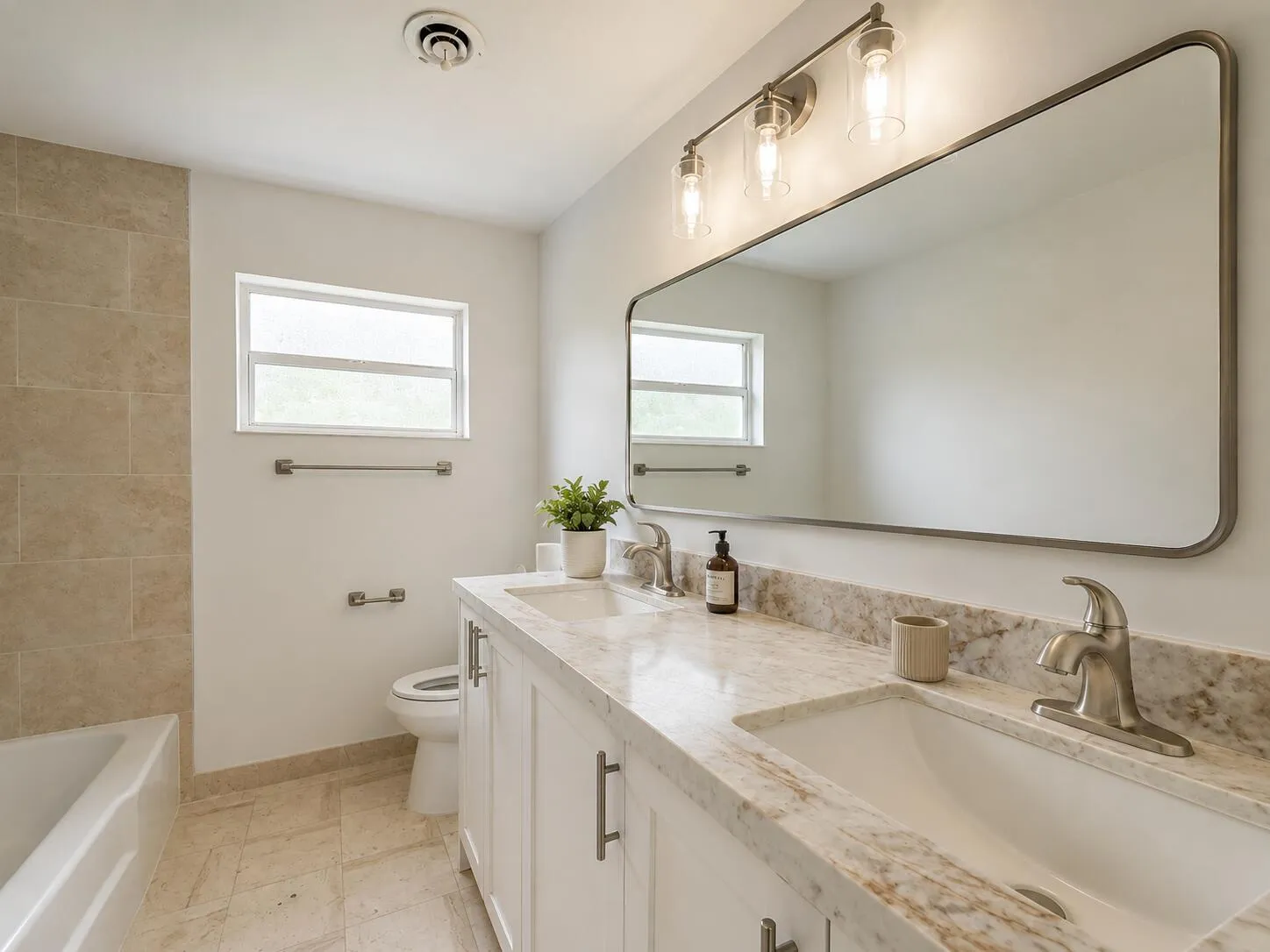 Dual vanity with integrated sinks, light-toned stone countertop, and brushed nickel fixtures