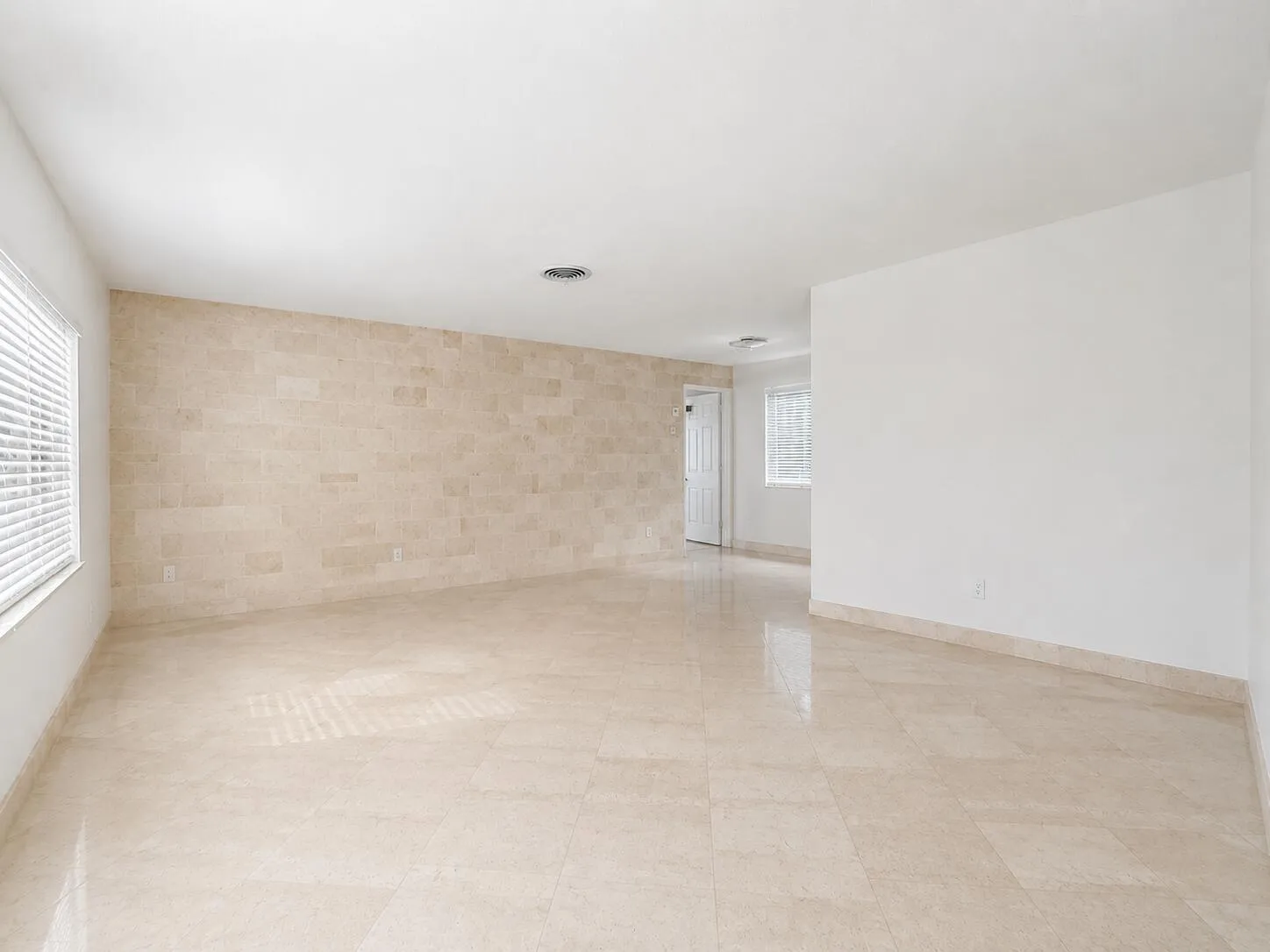 Recessed ceiling lighting, tiled flooring, tiled accent wall, and window with horizontal blinds