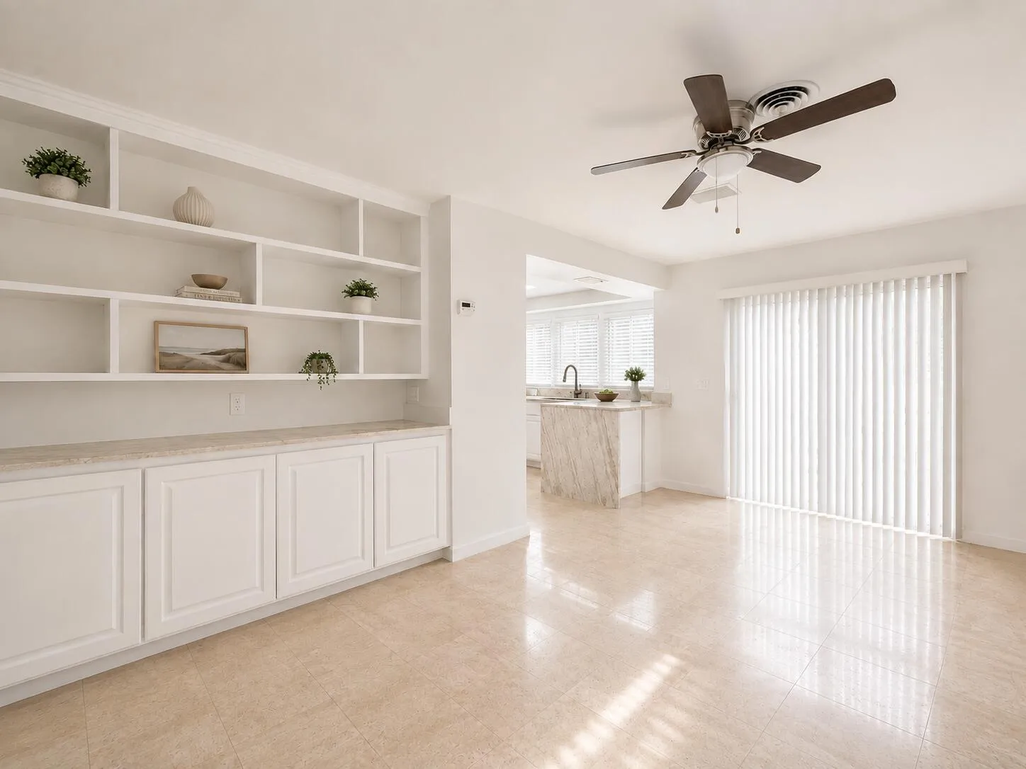 Built-in shelving with lower cabinetry, ceiling fan, tile flooring, and sliding glass door with vertical blinds