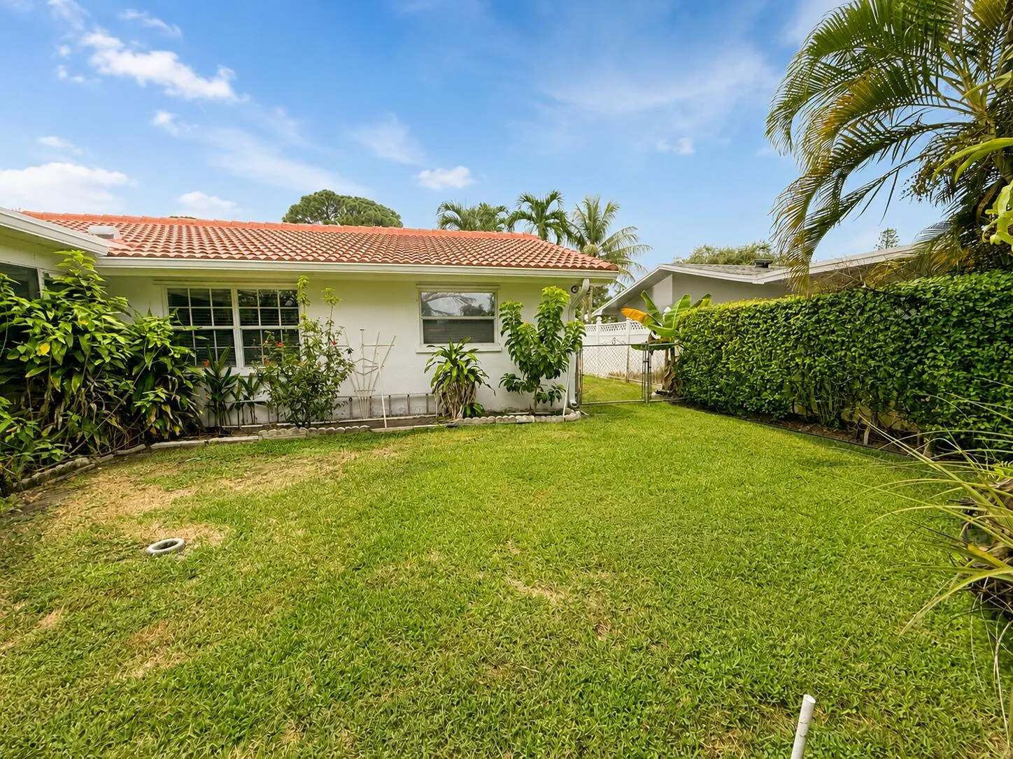 Expansive lawn area with mature hedges and a tiled roofline