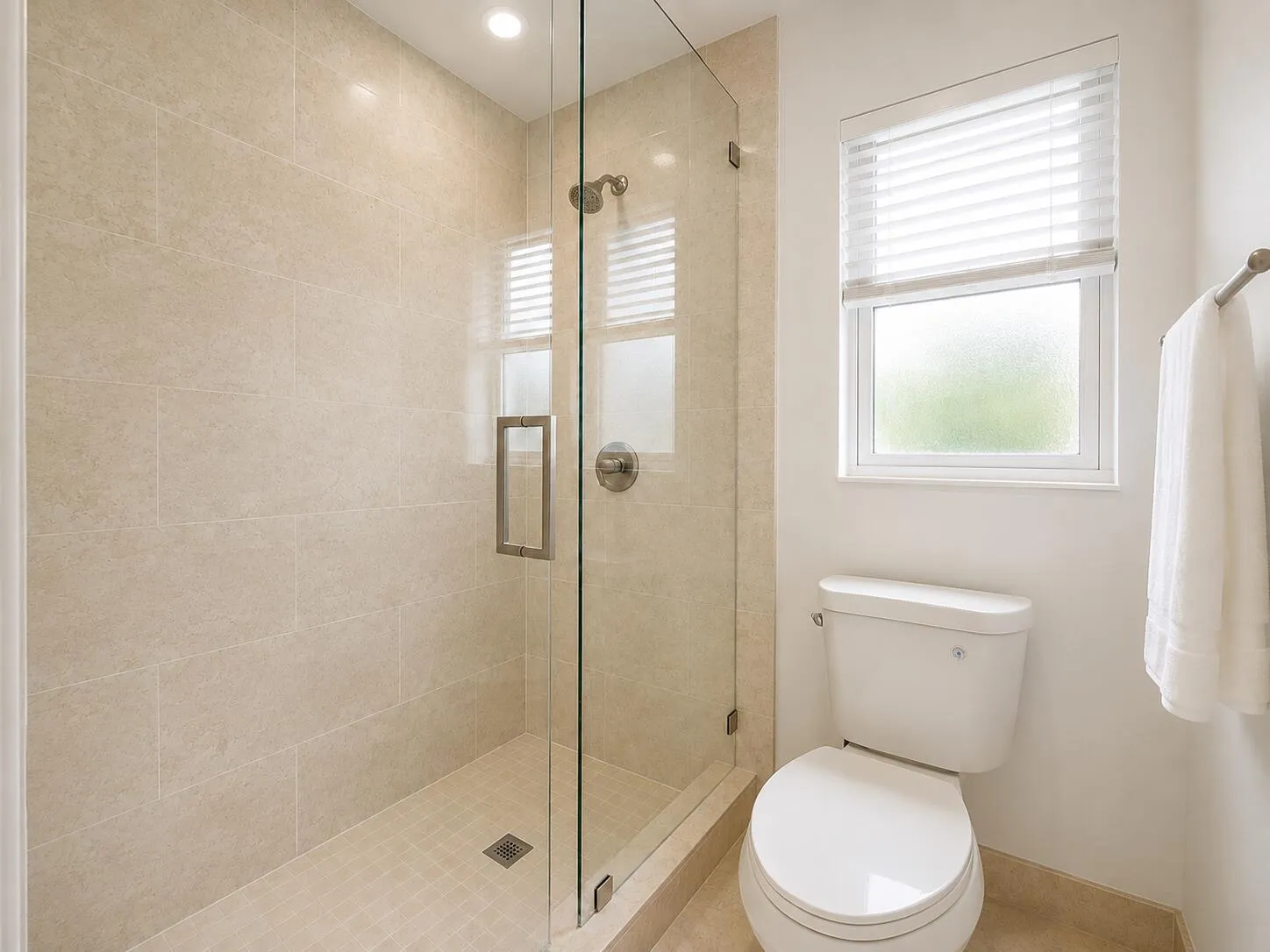 Glass-enclosed shower with tiled walls and floor, recessed lighting, and a white toilet