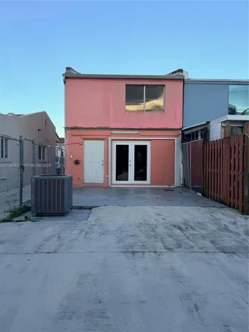 Exterior featuring stucco facade, double-pane glass French doors, solid entry door, sliding window, and concrete patio surface