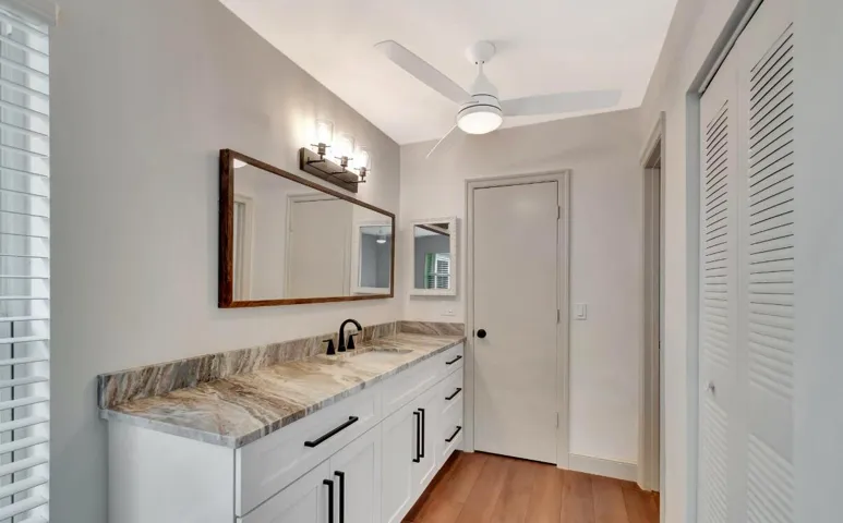 Double vanity with stone countertop, undermount sink, and matte black fixtures