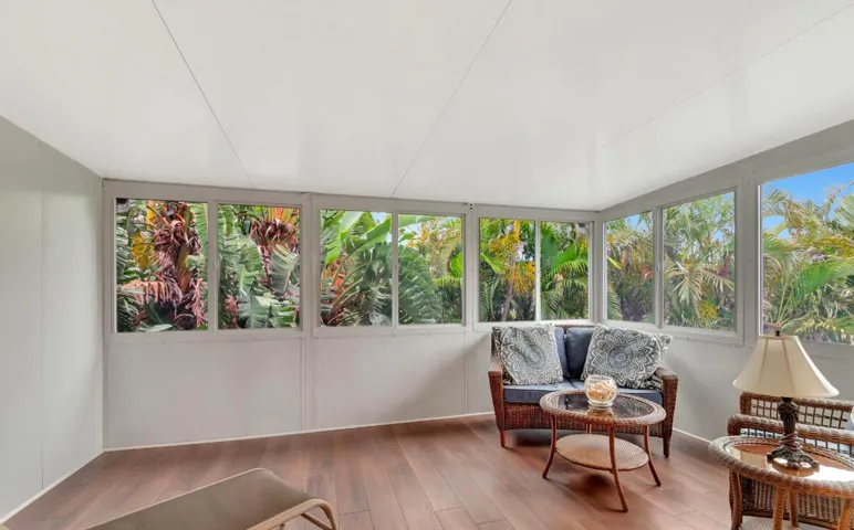 Enclosed sunroom featuring wood-finish flooring and multiple windows
