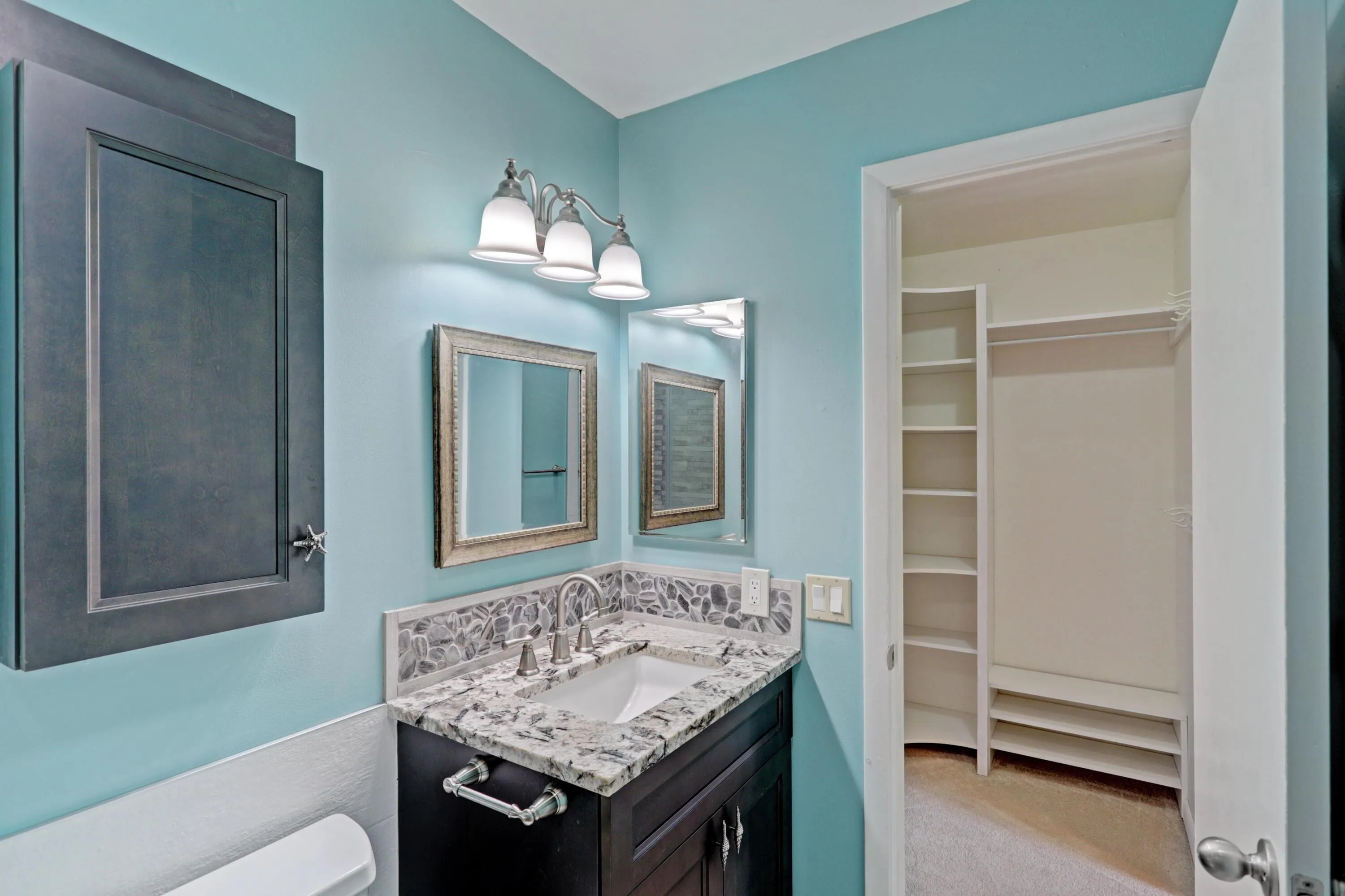 Vanity featuring a stone countertop, undermount sink, and brushed nickel faucet