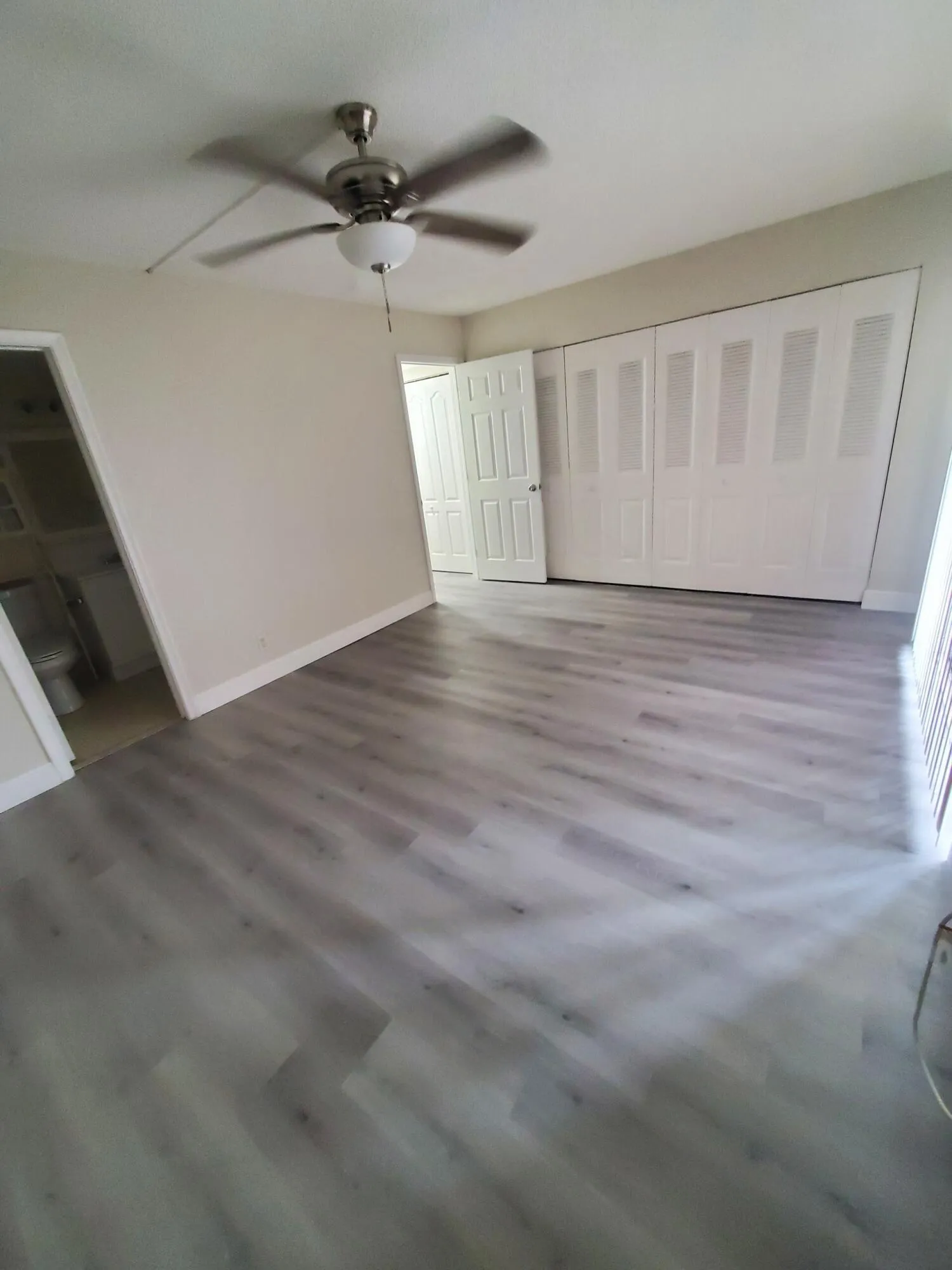 Neutral-toned walls complement wood-finish flooring with Wall Of Closet Space