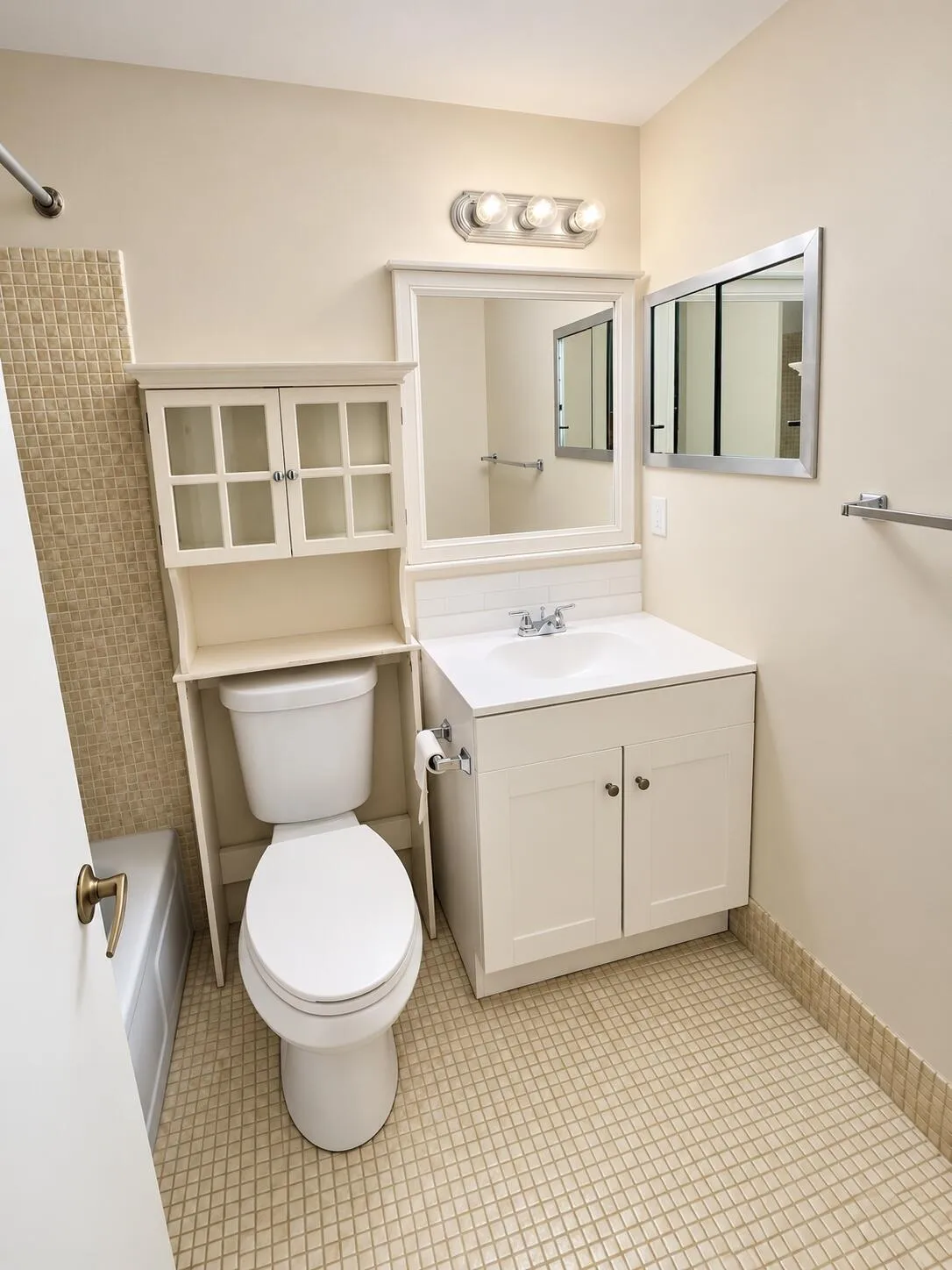 Vanity with integrated sink, white cabinetry, and mirror with overhead lighting
Public