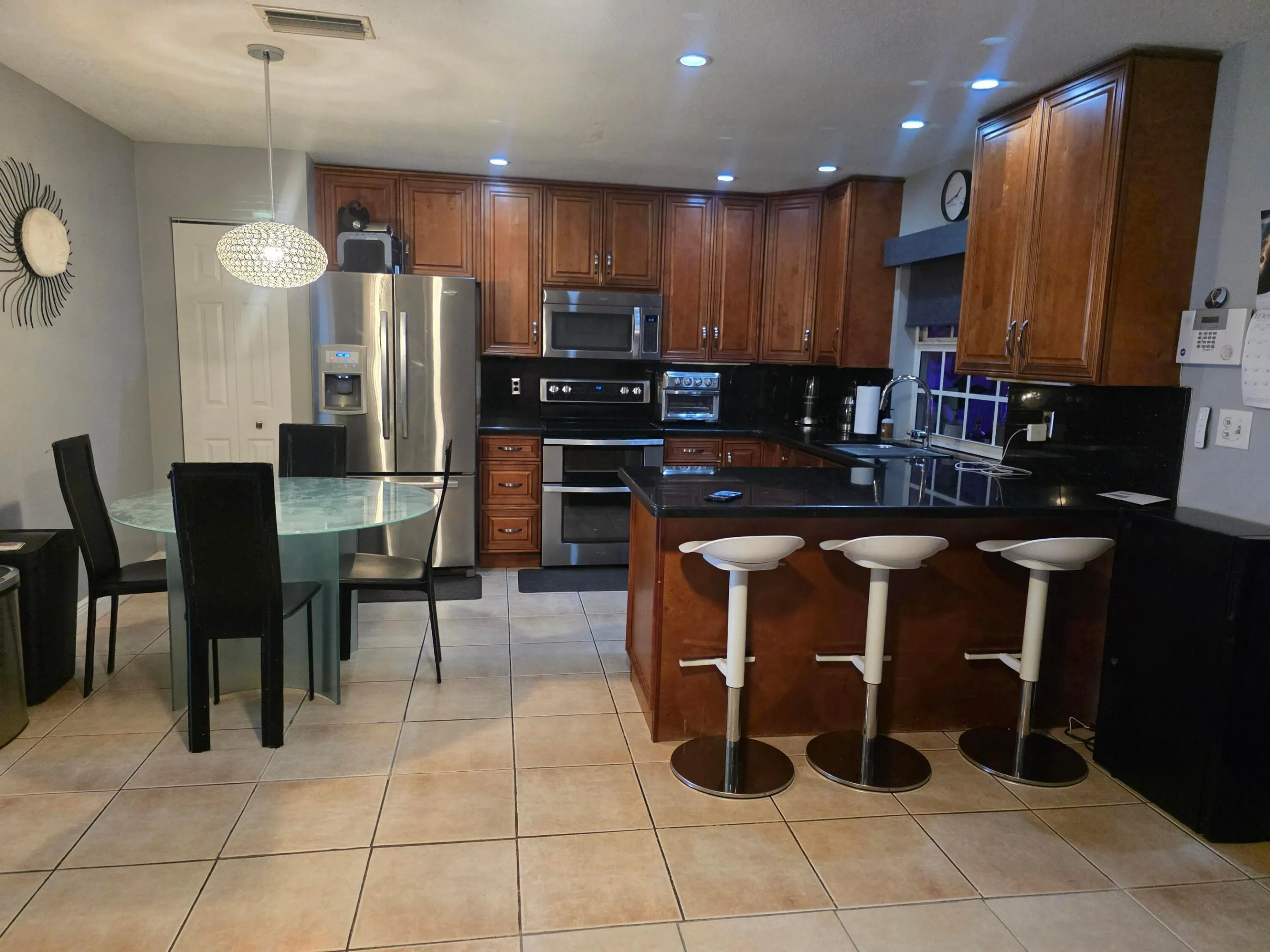 Wood-finish cabinetry paired with black countertops and stainless steel appliances
