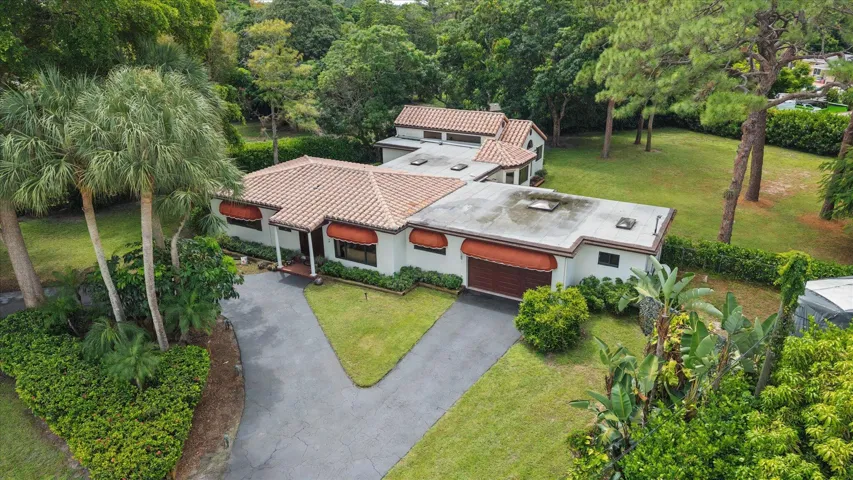 Aerial view shows original house horizontal in front and 1991 addition in the back. All windows on the original house are hurricane-rated. All windows on the addition have either clear or aluminum hurricane panels. Laundry room and 4th bathroom are to the right of the garage. Garage and laundry room have hurricane-rated skylights for natural lighting. Front house is CBS construction, back addition is frame construction on a 17