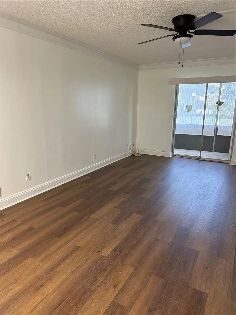 Large living room has new flooring, screened patio overlooks garden area.