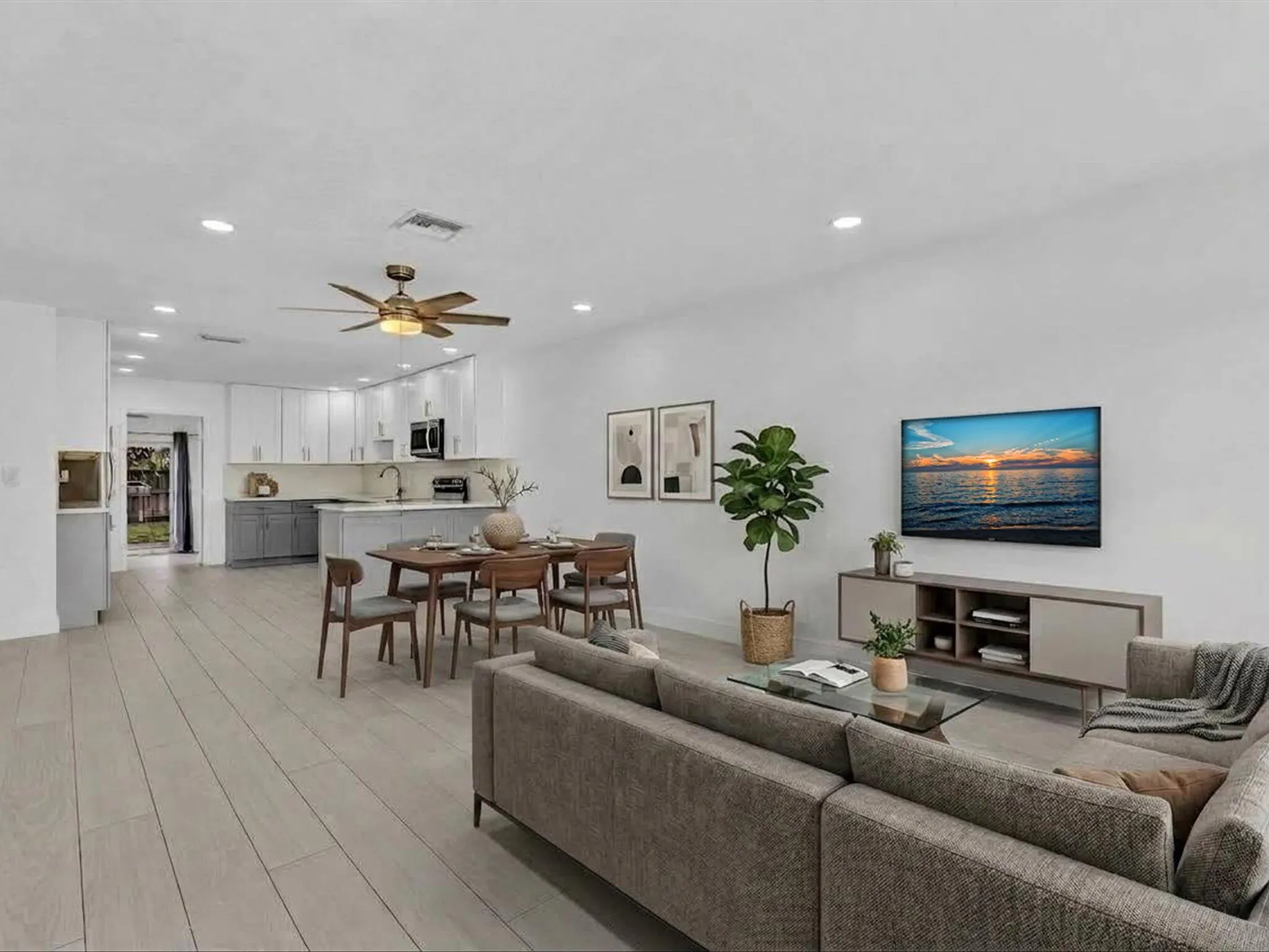 VIRTUALLY STAGED. Open-concept living space with light wood-finish vinyl flooring, recessed lighting, and a ceiling fan