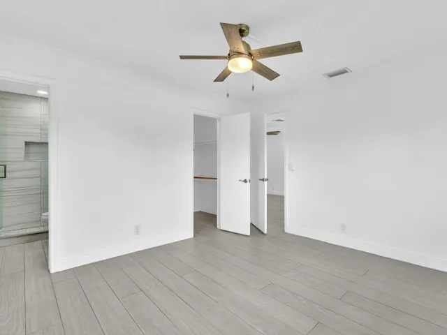 Bedroom with wood-finish ceiling fan with integrated lighting, and light grey vinyl flooring