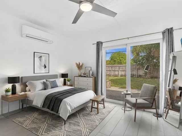 VIRTUALLY STAGED. Bedroom with wood-finish ceiling fan with integrated lighting, and light grey vinyl flooring, sliding door exit to backyard