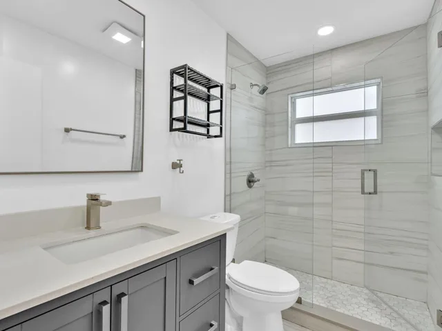 Walk-in shower with glass enclosure, tiled walls, and built-in niche