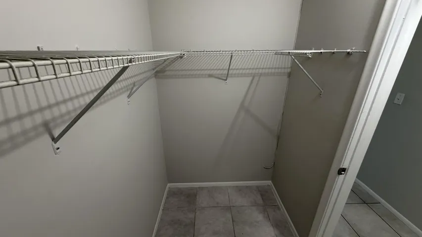 Integrated wire shelving system, neutral wall paint, and tiled flooring